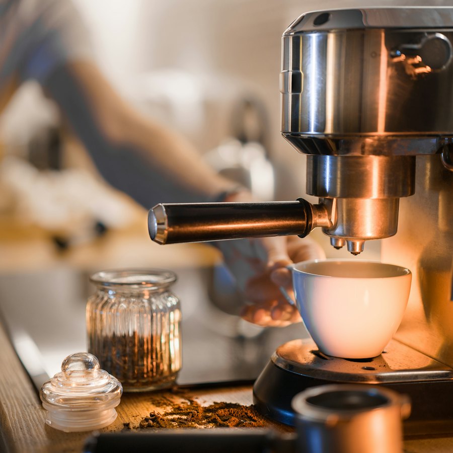 Espresso pouring into a cup at a home kitchen counter in warm morning light